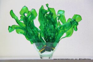 Hojas verdes y algas con botellas de plástico
